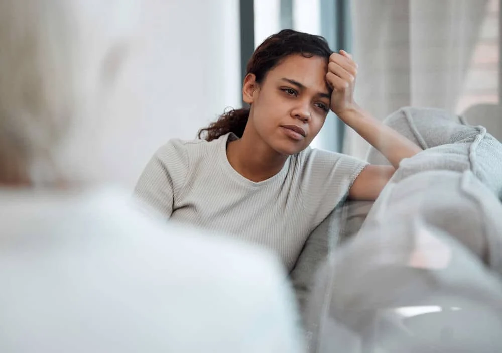 a woman with hand on her head staring out