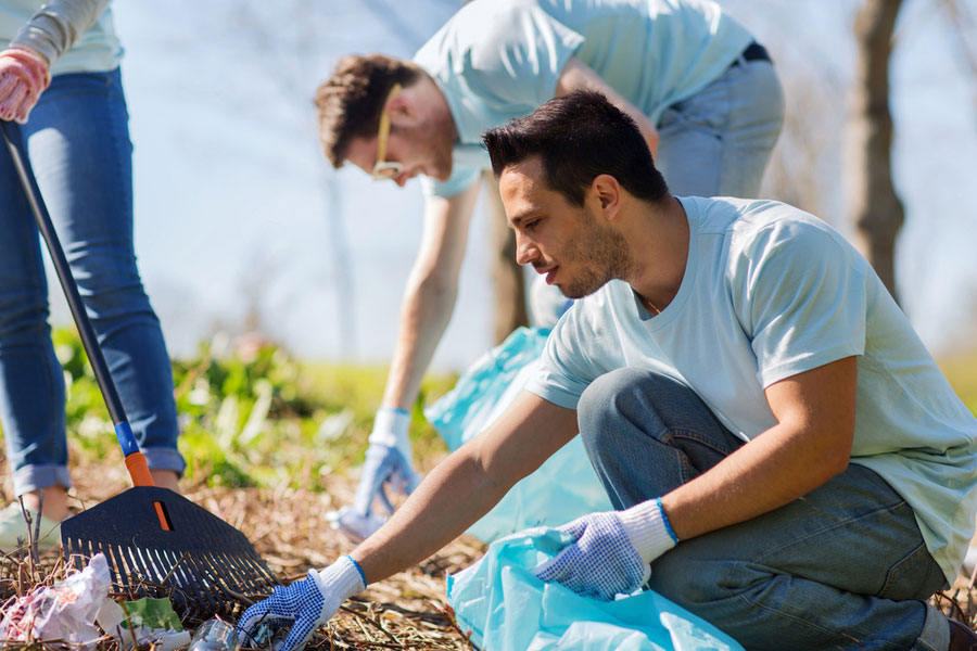 Concept of humility - young person volunteering to pick up litter