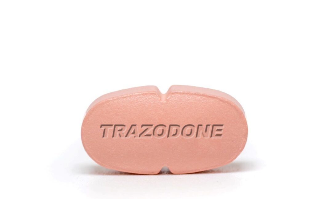 Trazodone medication tablet with engraved name, representing its use for treating depression and related insomnia.