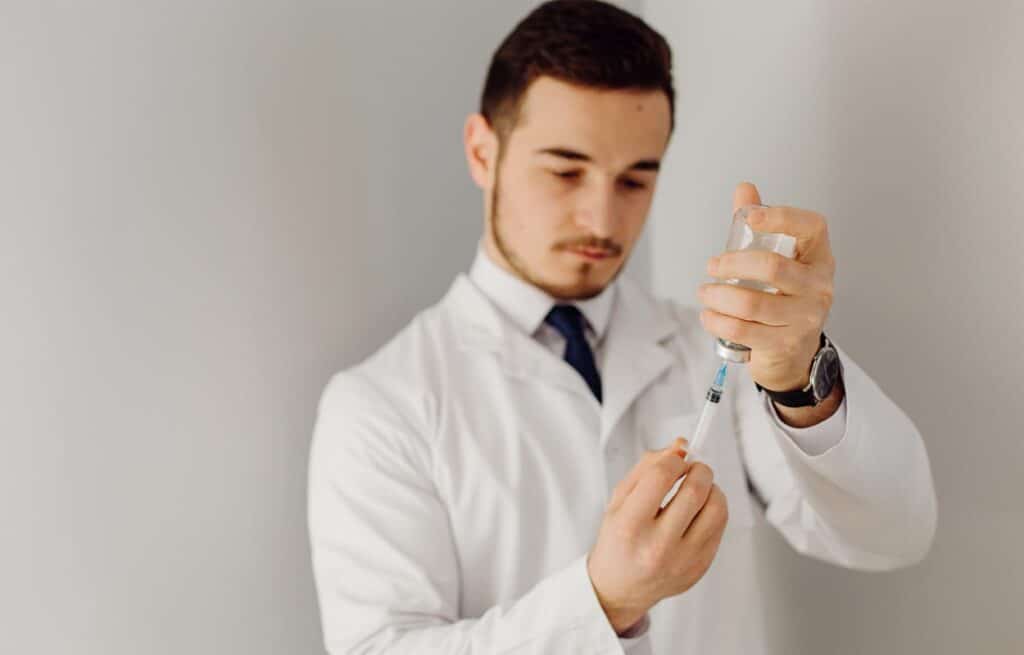 Doctor preparing Vivitrol injection, depicting injection site reactions and risks.