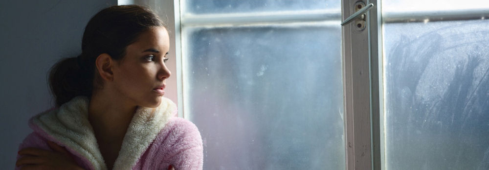 a-woman-staring-out-the-window-sad