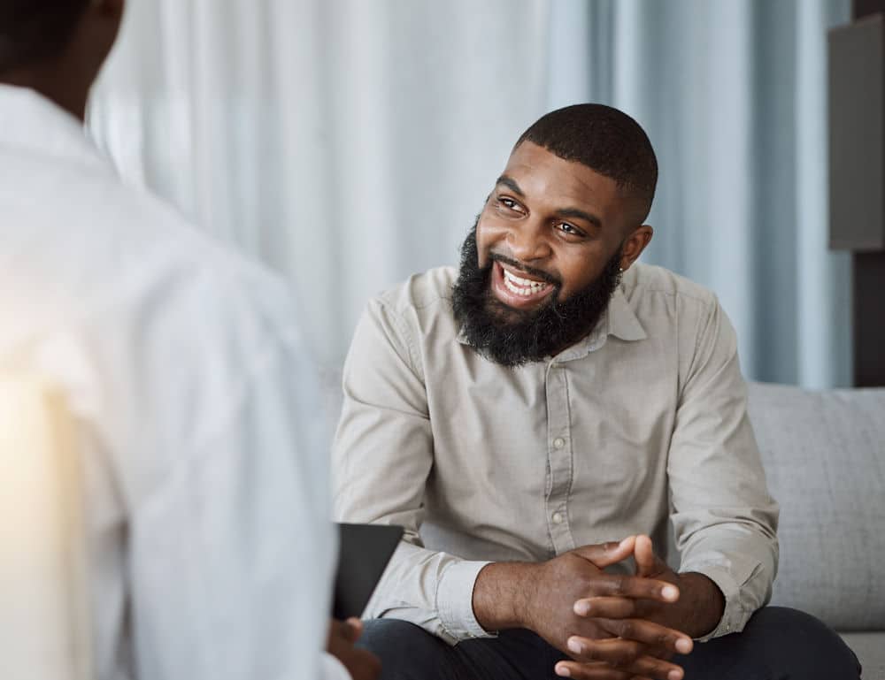 a man smiling in therapy session at therapist