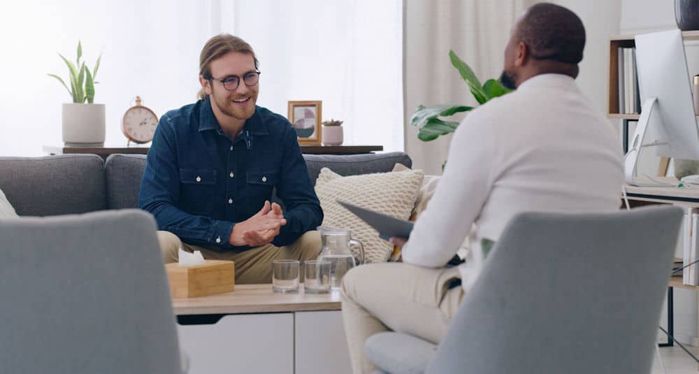 Man and therapist discussing addiction treatment and recovery at Ocean Recovery.